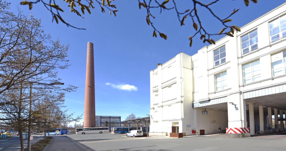 Außenansicht ASP-Gebäude mit Schornstein im Hintergrund